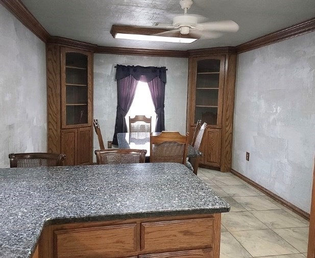 dining room featuring ornamental molding, ceiling fan, and baseboards