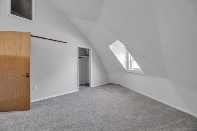additional living space with baseboards, lofted ceiling with skylight, and carpet floors