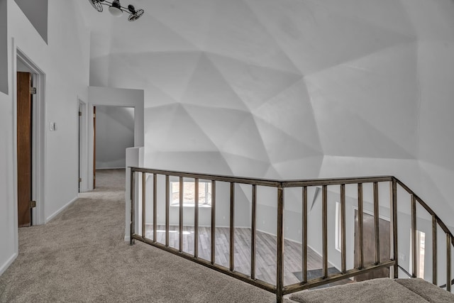 corridor featuring vaulted ceiling and carpet