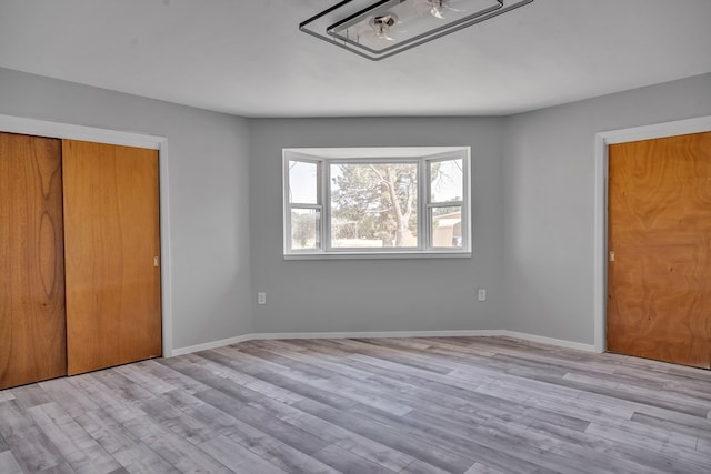 unfurnished bedroom featuring a closet, baseboards, and wood finished floors