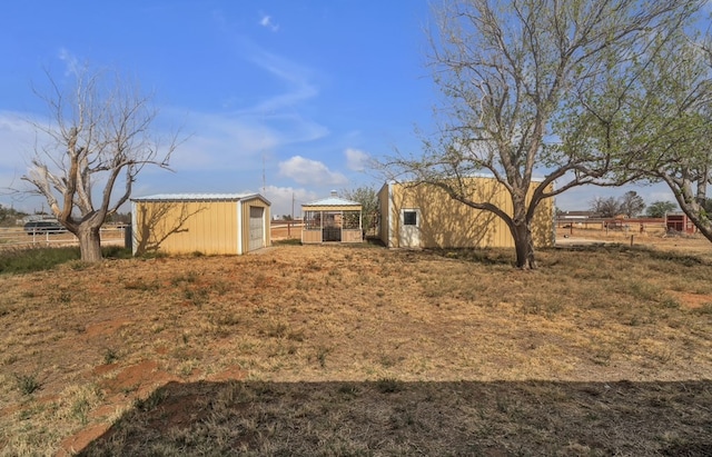 view of yard with an outdoor structure, fence, and a detached garage