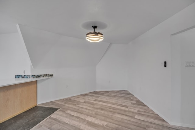 bonus room with baseboards, wood finished floors, and lofted ceiling