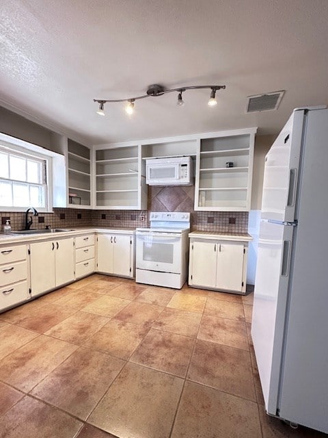 kitchen featuring visible vents, decorative backsplash, white cabinetry, a sink, and white appliances