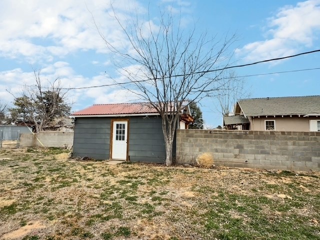 view of yard with a fenced backyard and an outbuilding