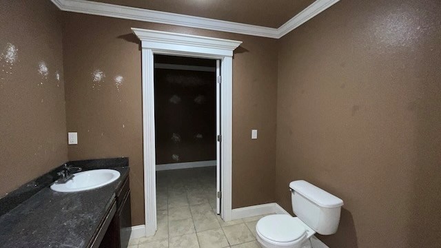 bathroom featuring vanity, toilet, and crown molding