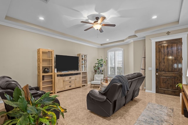 living room featuring crown molding, ceiling fan, and a tray ceiling