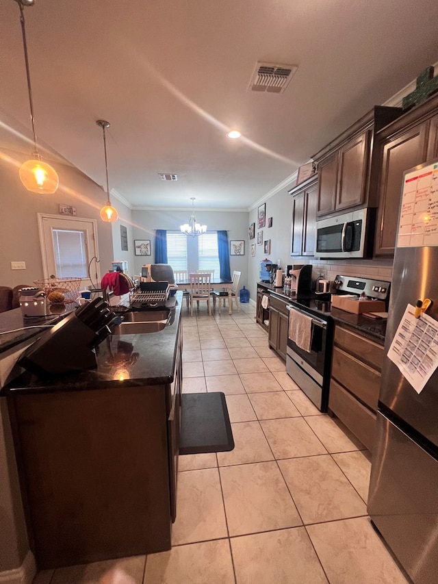 kitchen with appliances with stainless steel finishes, dark brown cabinets, pendant lighting, and light tile patterned floors