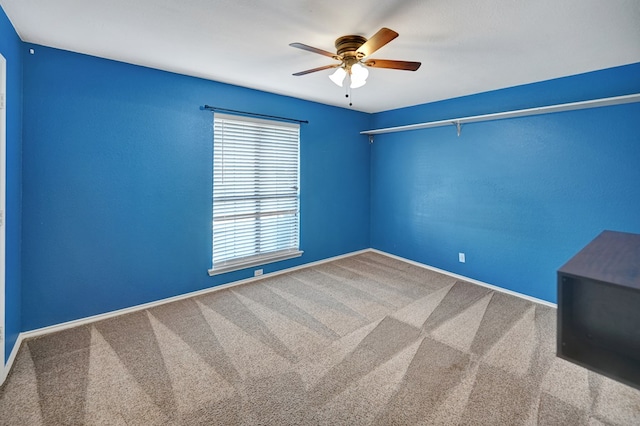 unfurnished room featuring baseboards, a ceiling fan, and carpet flooring