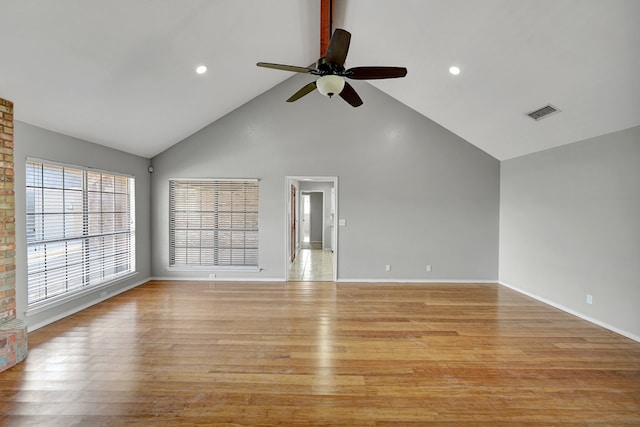 unfurnished room with visible vents, baseboards, high vaulted ceiling, and light wood finished floors