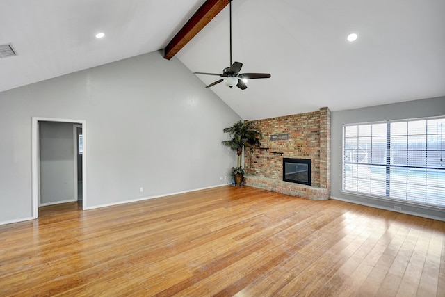 unfurnished living room featuring visible vents, beam ceiling, light wood finished floors, a brick fireplace, and ceiling fan