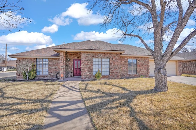 ranch-style home with brick siding, an attached garage, concrete driveway, and a front lawn