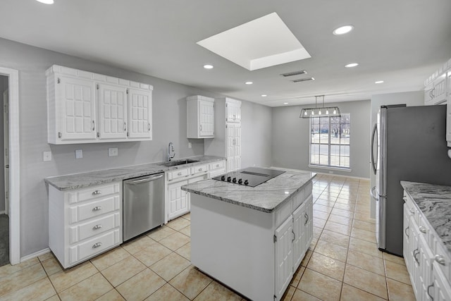 kitchen with light stone counters, visible vents, a sink, stainless steel appliances, and a center island