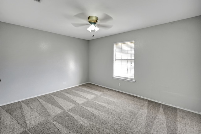 empty room with baseboards, carpet floors, and a ceiling fan