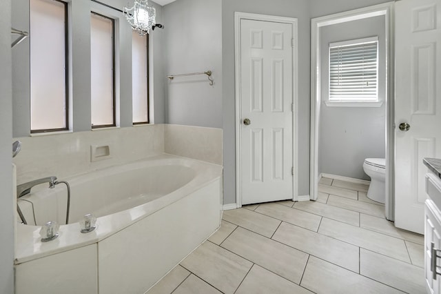 full bathroom featuring toilet, a bath, and vanity