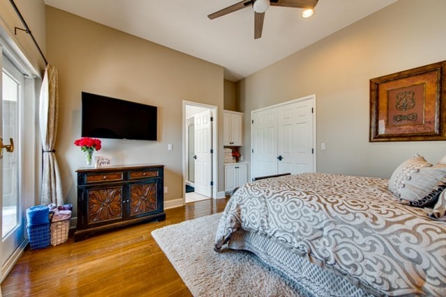 bedroom featuring ceiling fan, light wood-type flooring, and lofted ceiling