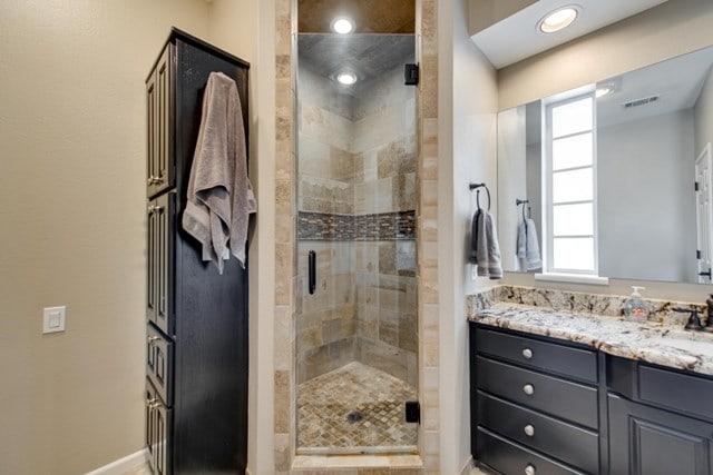 bathroom featuring vanity and a shower with shower door