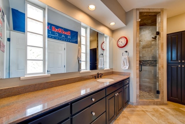 bathroom featuring tile patterned floors, vanity, a healthy amount of sunlight, and a shower with shower door