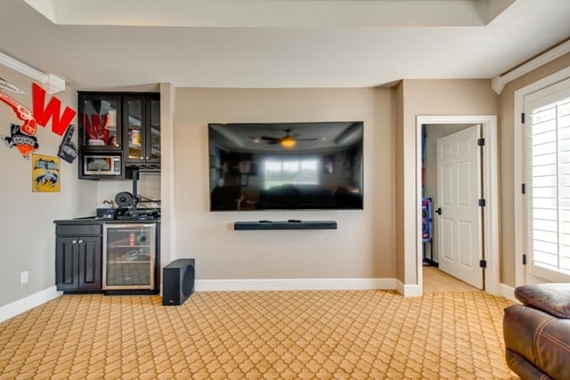 living room with carpet floors, beverage cooler, and indoor bar