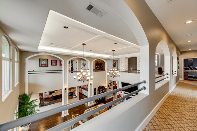 corridor featuring a chandelier, carpet floors, and a tray ceiling