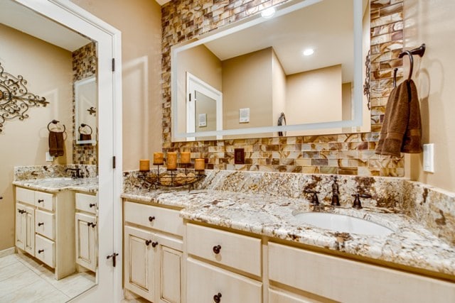 bathroom with decorative backsplash, tile patterned flooring, and vanity