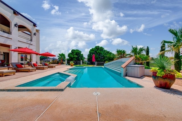 view of pool with an in ground hot tub and a patio area