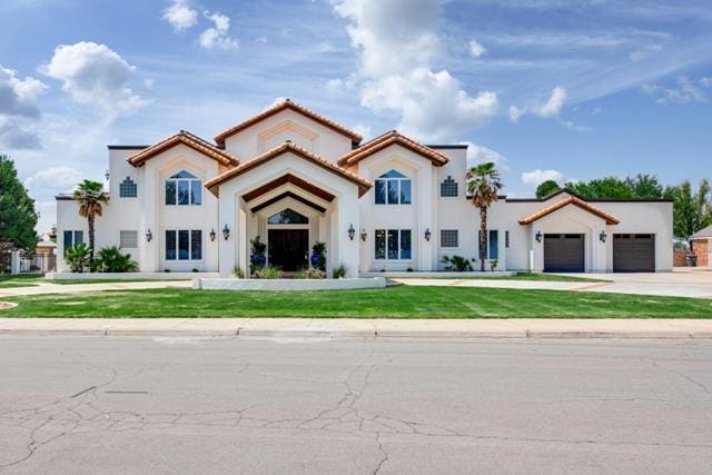 mediterranean / spanish house with a front lawn and a garage