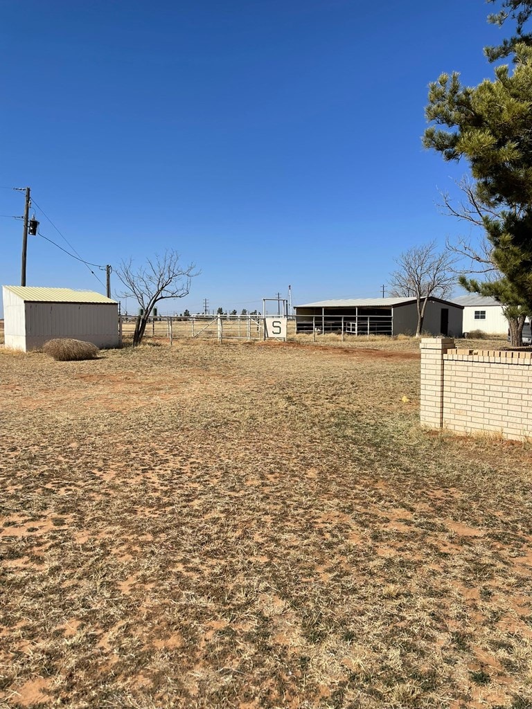 view of yard featuring a rural view and an outdoor structure