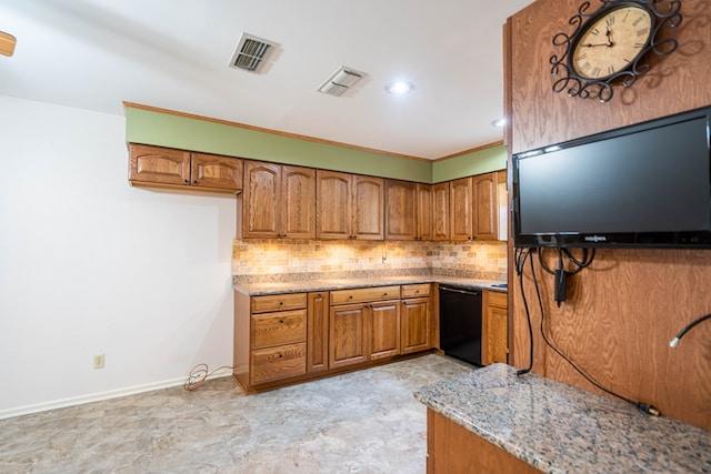 1509 Cascade Ct, Midland, TX 79703 - kitchen featuring black dishwasher, brown cabinetry, light stone counters, and backsplash