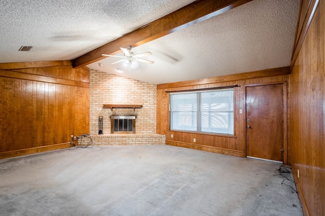 1509 Cascade Ct, Midland, TX 79703 - unfurnished living room with wooden walls, carpet flooring, ceiling fan, a fireplace, and a textured ceiling