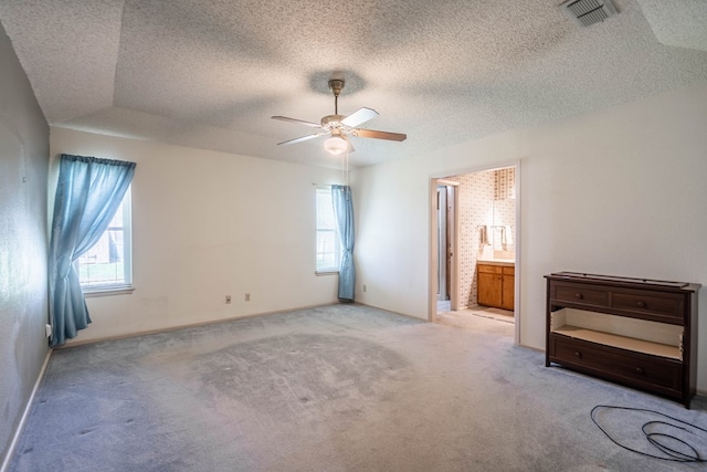1509 Cascade Ct, Midland, TX 79703 - unfurnished bedroom with multiple windows, carpet floors, a textured ceiling, and connected bathroom