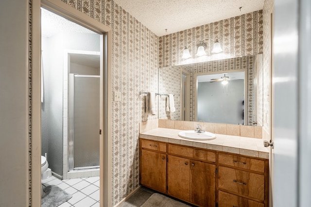 1509 Cascade Ct, Midland, TX 79703 - bathroom with wallpapered walls, vanity, a stall shower, a textured ceiling, and ceiling fan