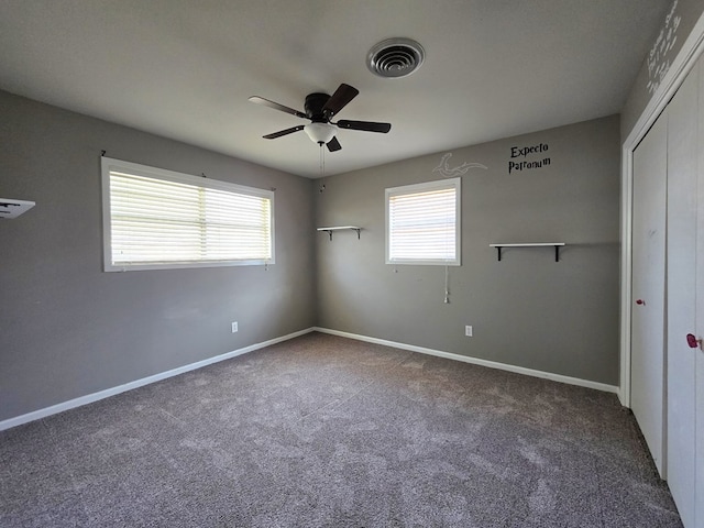 carpeted spare room with ceiling fan