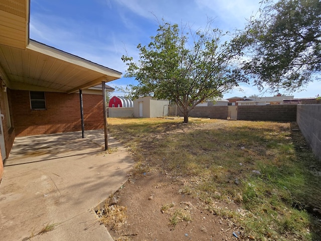 view of yard featuring a storage unit and a patio area