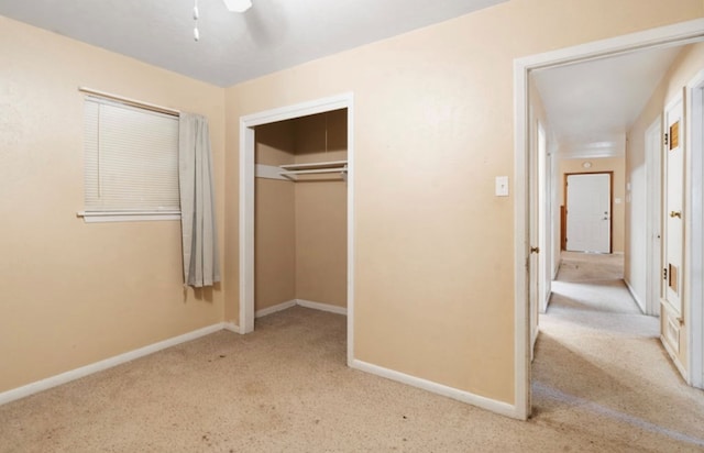 unfurnished bedroom with baseboards, a closet, and light colored carpet