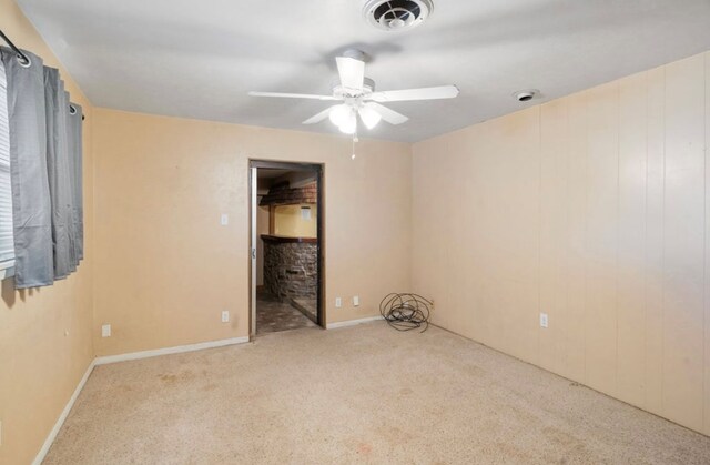 empty room with a ceiling fan, visible vents, and light carpet