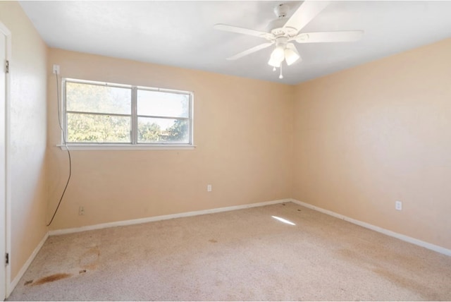 unfurnished room featuring ceiling fan, baseboards, and light colored carpet