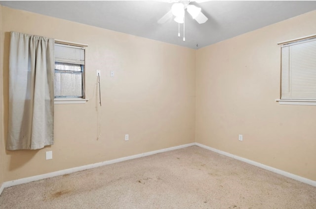 spare room with a ceiling fan, carpet flooring, and baseboards