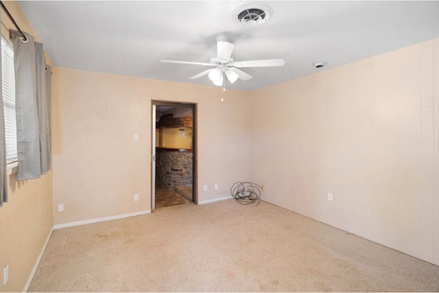 empty room with a ceiling fan, visible vents, and light carpet