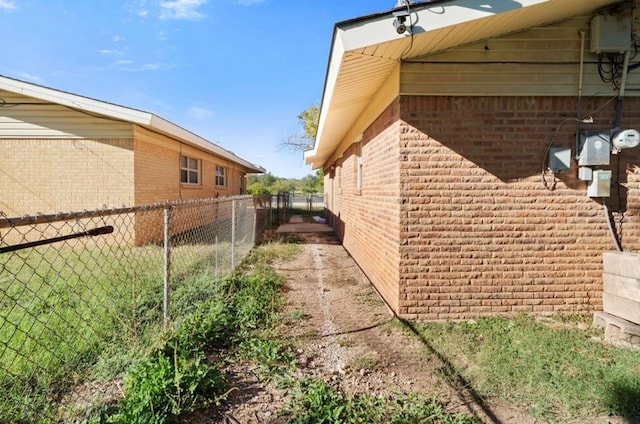 view of home's exterior featuring brick siding and fence