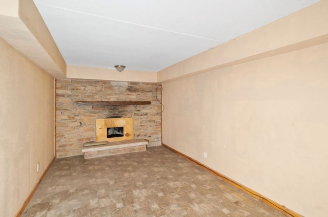 unfurnished living room featuring a fireplace and baseboards