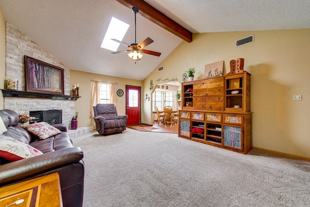10903 E County Rd 105, Midland, TX 79706 - living room featuring carpet flooring, a stone fireplace, a textured ceiling, ceiling fan, and a skylight
