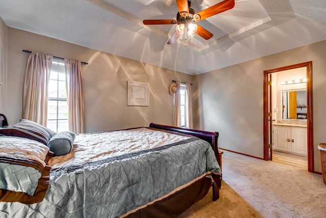 10903 E County Rd 105, Midland, TX 79706 - bedroom with multiple windows, light carpet, baseboards, connected bathroom, and a textured ceiling