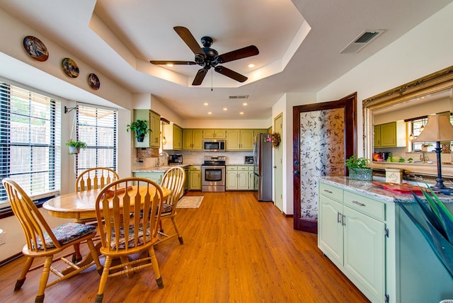 10903 E County Rd 105, Midland, TX 79706 - dining area with a raised ceiling, ceiling fan, light wood-type flooring, recessed lighting, and baseboards