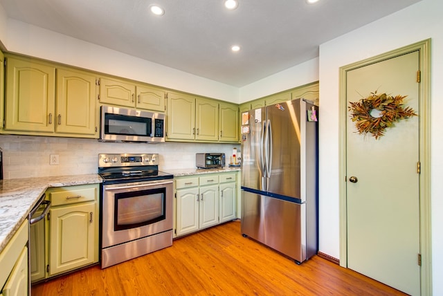 10903 E County Rd 105, Midland, TX 79706 - kitchen with appliances with stainless steel finishes, green cabinetry, light wood-style floors, tasteful backsplash, and recessed lighting