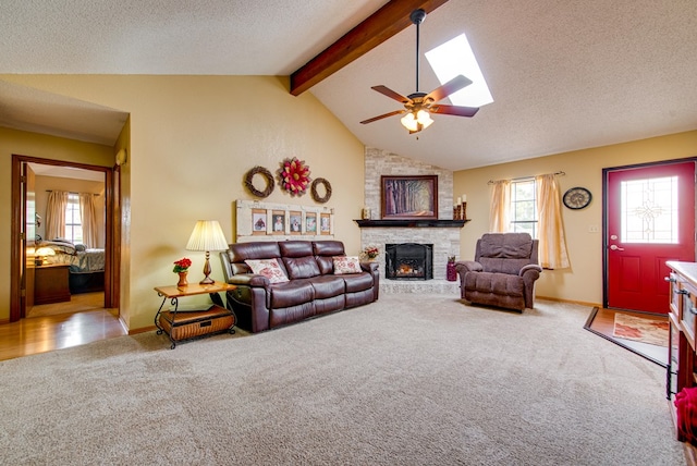 10903 E County Rd 105, Midland, TX 79706 - carpeted living area with a fireplace, ceiling fan, a skylight, baseboards, and a textured ceiling