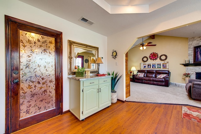 10903 E County Rd 105, Midland, TX 79706 - bar area featuring ceiling fan, arched walkways, light wood finished floors, a stone fireplace, and baseboards
