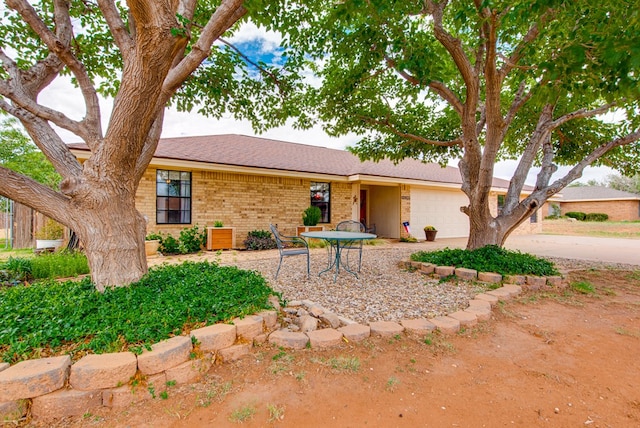 10903 E County Rd 105, Midland, TX 79706 - view of front of property with a garage, brick siding, driveway, and a shingled roof