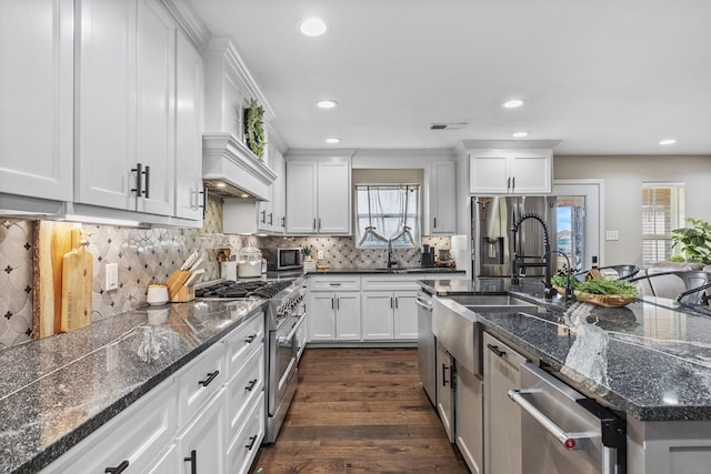 kitchen with appliances with stainless steel finishes, a sink, and white cabinets