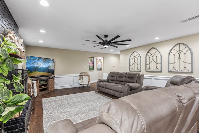 living area with a decorative wall, wainscoting, dark wood finished floors, and recessed lighting