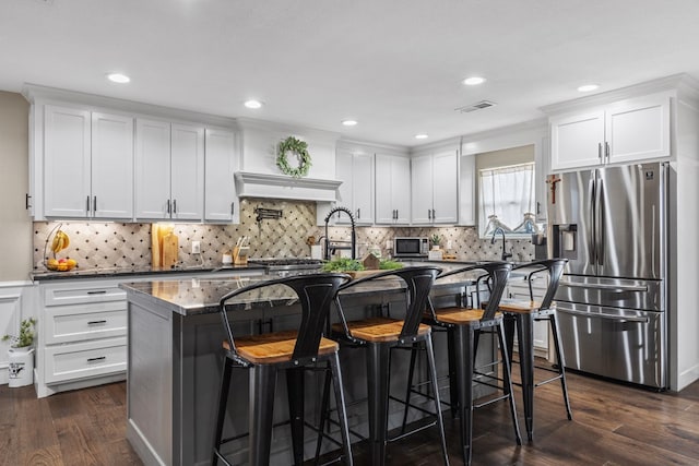 kitchen with white cabinetry, dark wood-style floors, visible vents, and appliances with stainless steel finishes